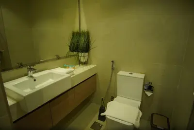 a bathroom with a sink and a toilet and a mirror at Spacious Studio with full Burj Khalifa view Jaddaf in Dubai