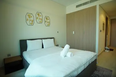 a bedroom with a large bed with white sheets at Spacious Studio with full Burj Khalifa view Jaddaf in Dubai