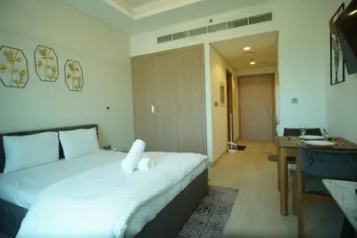 a bedroom with a bed and a desk in a room at Spacious Studio with full Burj Khalifa view Jaddaf in Dubai