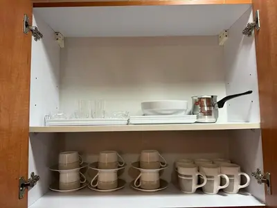 a cupboard with a bunch of cups and plates at Livincci - Luxury Studio in Dubai Marina - 16 in Dubai