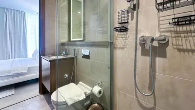 a bathroom with a shower and a toilet and a sink at Spacious 2BR, Sobha Waves, Family-Friendly Stay - 3AB11 in Dubai