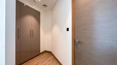 a hallway with a door and a wooden floor at Spacious 2BR, Sobha Waves, Family-Friendly Stay - 3AB11 in Dubai