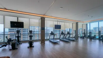 a gym with a lot of treadmills and exercise bikes at Spacious 2BR, Sobha Waves, Family-Friendly Stay - 3AB11 in Dubai