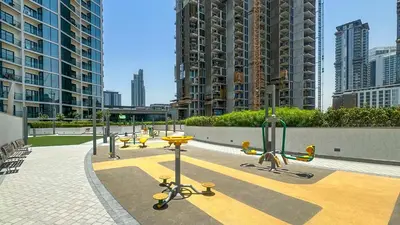 a row of tables and benches in a city with tall buildings at Spacious 2BR, Sobha Waves, Family-Friendly Stay - 3AB11 in Dubai