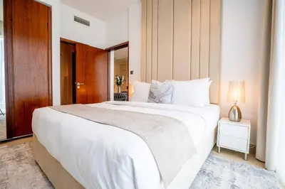 a bedroom with a large white bed and a window at Amazing Pool LUX Location 1 Bedroom Apartment in Dubai