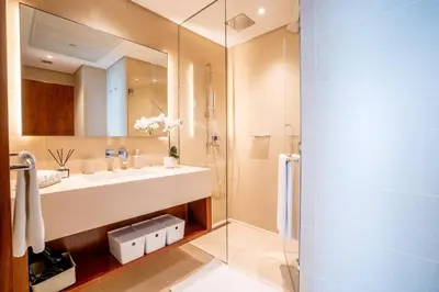 a bathroom with a sink and a shower at Amazing Pool LUX Location 1 Bedroom Apartment in Dubai