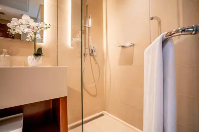 a bathroom with a shower with a glass door at Amazing Pool LUX Location 1 Bedroom Apartment in Dubai