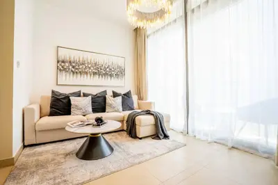 a living room with a couch and a table at Amazing Pool LUX Location 1 Bedroom Apartment in Dubai