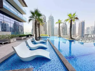 a hotel swimming pool with palm trees and buildings at Amazing Pool LUX Location 1 Bedroom Apartment in Dubai