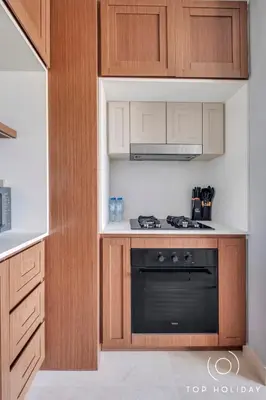 a kitchen with wooden cabinets and a black oven at Luxury High floor apartment Atlantis & palm view in Dubai