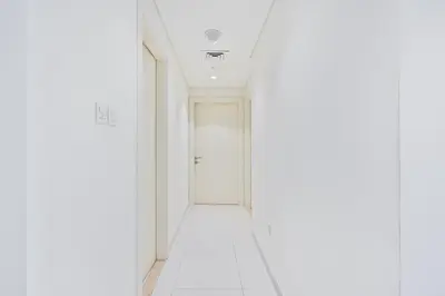 a hallway with white walls and a white door at Stylish 2BR - Near Burj Khalifa & City Views in Dubai