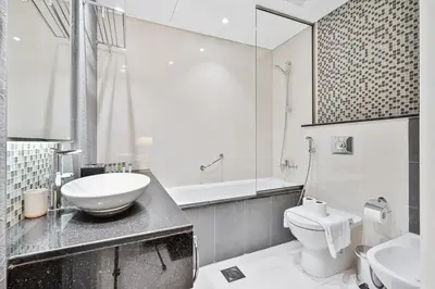 a white bathroom with a sink and a toilet at Stylish 2BR - Near Burj Khalifa & City Views in Dubai