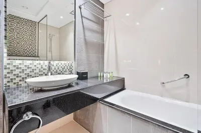 a bathroom with a sink and a bath tub at Stylish 2BR - Near Burj Khalifa & City Views in Dubai