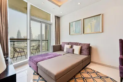a living room with a couch and a large window at Stylish 2BR - Near Burj Khalifa & City Views in Dubai