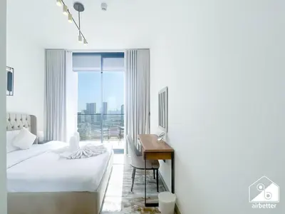a bedroom with a bed and a desk and a window at Bright and Modern 1BR Binghatti Amber with City View in Dubai