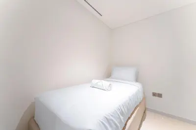 a white bed in a white room with a white pillow at Seafront 3BR with maid's - Grand Bleu by Elie Saab in Dubai