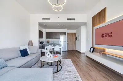 a living room with a couch and a tv at GuestReady - Golden paradise in Dubai Hills in Dubai