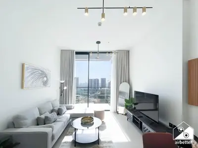 a living room with a couch and a tv at Cozy Luxury l1BR Apartment in Binghatti Amber in Dubai