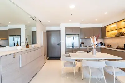 a kitchen and dining room with a table and chairs at Elie Saab Tower Luxury Apartment in Dubai