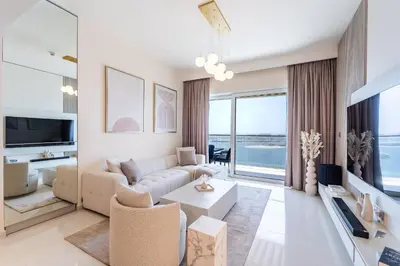 a living room with a couch and a table at Elie Saab Tower Luxury Apartment in Dubai