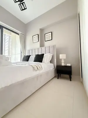 a white bedroom with a large bed and a window at Sunset Balcony - Sleeps 4 - Water View - Pool n Gym - 1BR in Dubai