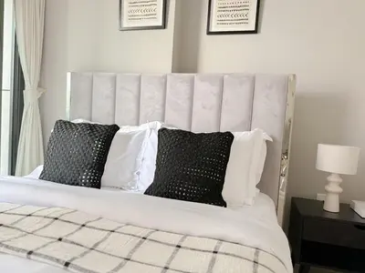 a bedroom with a bed with black and white pillows at Sunset Balcony - Sleeps 4 - Water View - Pool n Gym - 1BR in Dubai