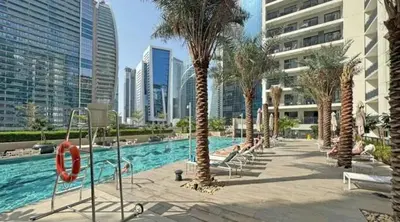 a swimming pool with palm trees in a city at Sunset Balcony - Sleeps 4 - Water View - Pool n Gym - 1BR in Dubai