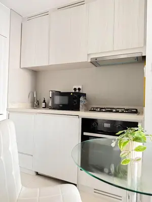 a kitchen with a glass table and a microwave at Sunset Balcony - Sleeps 4 - Water View - Pool n Gym - 1BR in Dubai