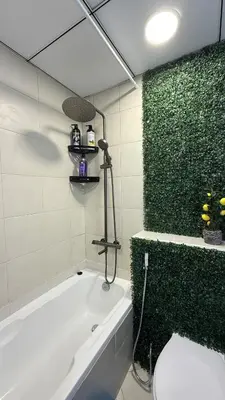 a bathroom with a white tub and a green wall at Livincci - Luxury 1 Bed Apartment in JLT-10 in Dubai