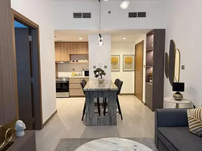 a kitchen and living room with a table and chairs at Canal View 1BR - Business Bay - Fully Furnished in Dubai