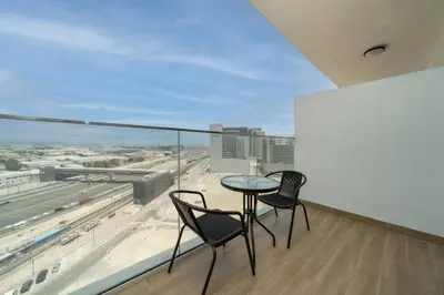 two chairs and a table on a balcony with a view at Contemporary Studio Getaway in Jebel Ali in Dubai