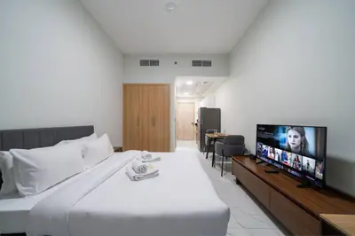 a hotel room with a bed and a flat screen tv at Contemporary Studio Getaway in Jebel Ali in Dubai