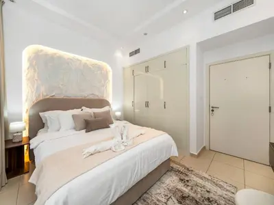 a bedroom with a large white bed with a large headboard at Best Marina & Ain Dubai View | Steps to JBR beach in Dubai