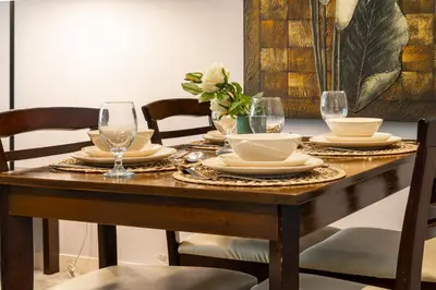 a wooden table with plates and glasses on it at Peace Of The Soul By Lagom Jumeirah Lake Towers in Dubai