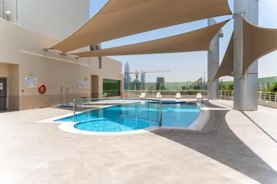a swimming pool in a building with a large umbrella at Peace Of The Soul By Lagom Jumeirah Lake Towers in Dubai