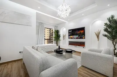 a living room with two couches and a tv at Chic 2BR Steps to JBR Beach in Dubai