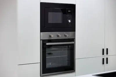a black microwave oven sitting inside of a kitchen at Chic 2BR Steps to JBR Beach in Dubai