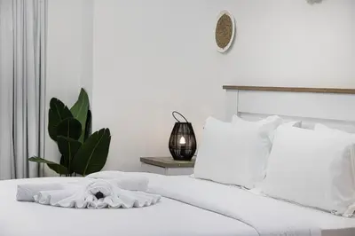 a white bedroom with a white bed with white pillows at Chic 2BR Steps to JBR Beach in Dubai