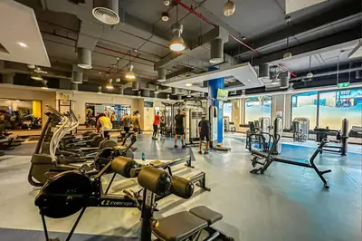 a gym with many cardio machines and people in it at Chic 2BR Steps to JBR Beach in Dubai