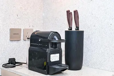 a knife block next to a black appliance on a counter at New Luxe 2BR in Burj Royale, 1 Min Walk to Dubai Mall,40th Floor, Burj Khalifa View Pool, Wifi, Gym in Dubai