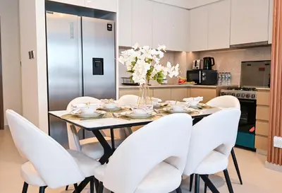 a dining room with a table and white chairs at New Luxe 2BR in Burj Royale, 1 Min Walk to Dubai Mall,40th Floor, Burj Khalifa View Pool, Wifi, Gym in Dubai