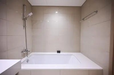 a white tub in a bathroom with a shower at New Luxe 2BR in Burj Royale, 1 Min Walk to Dubai Mall,40th Floor, Burj Khalifa View Pool, Wifi, Gym in Dubai