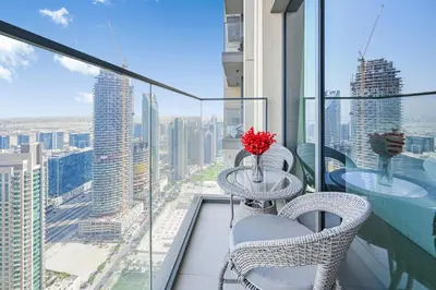 a balcony with two tables and chairs and a view of a city at New Luxe 2BR in Burj Royale, 1 Min Walk to Dubai Mall,40th Floor, Burj Khalifa View Pool, Wifi, Gym in Dubai