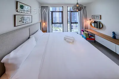 a large white bed in a room with a window at Creek Crescent by Emaar, Dubai Creek Harbour in Dubai