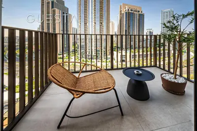 a balcony with a chair and a table and buildings at Creek Crescent by Emaar, Dubai Creek Harbour in Dubai