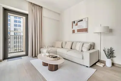 a white living room with a couch and a table at 1-Bed at Creek Beach with Pool, Gym and Balcony in Dubai