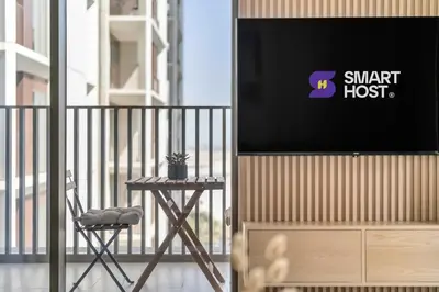 a flat screen tv on a balcony with a chair at 1-Bed at Creek Beach with Pool, Gym and Balcony in Dubai
