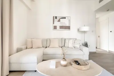 a living room with a white couch and a table at 1-Bed at Creek Beach with Pool, Gym and Balcony in Dubai