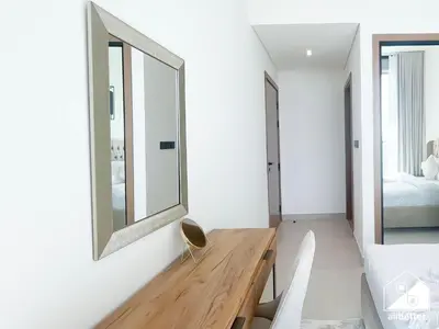 a bedroom with a wooden desk and a mirror at Stylish 1 Bedroom with Pool Access in JVC in Dubai