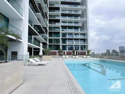 a swimming pool in front of a building at Stylish 1 Bedroom with Pool Access in JVC in Dubai